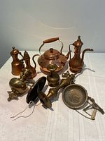 All items grouped: copper kettle, three copper ewers, assorted brass candlestick/finial parts, light canopy, dish