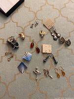 Group shot of all eleven earring pairs laid out on fabric