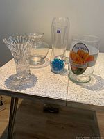 Group shot of four vases showing cut-crystal, bulb bowl, narrow with beads, and tulip vase