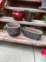 four ceramic planters on stairs showing shapes and finishes