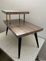 Full view of two-tier side table, showing surfaces, legs, and overall form