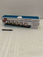 Boxed snowflake candle set beside pen for scale