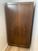 Closed wardrobe showing paneled doors and knobs