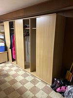Three matching wood-veneer wardrobes side by side