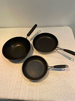 Top view showing three pans with interiors and handles