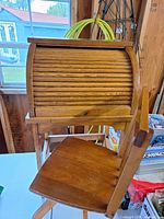 Roll-top desk closed with chair in foreground