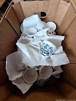 Box containing multiple blue onion pattern cups