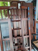 disassembled mahogany loft bed frame sections with ladder and rails