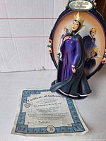 Front view of Evil Queen figurine with COA displayed