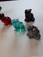 Group shot of four glass cat figurines in different colours