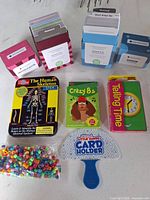 All items grouped: flash card sets, card games, skeleton tin, beads, card holder