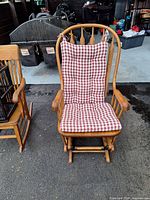 Front view of wooden glider chair with red and white checkered cushions