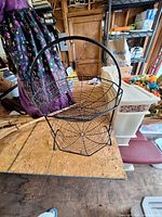 Two-tier spider web basket on plywood surface