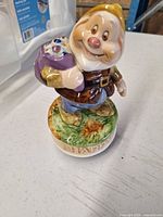 Front view of Happy dwarf figurine on base