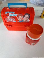 Front of red Howdy Doody lunch box and thermos