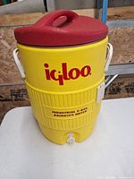 Front view showing Igloo logo, 5-gal designation, spigot and cup dispenser mount