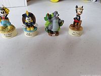 Front view of all four Lenox Disney figurines showing character poses and titled bases