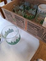 Box of pine-tree printed tumblers with one glass shown separately