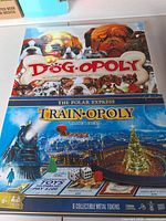 Front view of Dog-Opoly and Train-Opoly sealed boxes