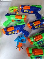 Four large and two small dart blasters on table