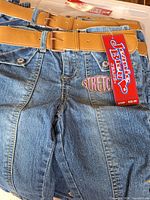 Two pairs of Jeanie Blu size 14 jeans with belts and tags