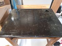 Top view of wooden school desk black surface with ink-well hole