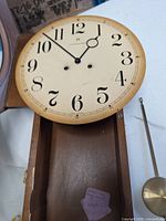 Wall clock case open showing dial and interior