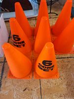 Eight bright orange training cones arranged upright