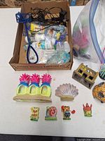 Overview of lot showing fish net, bottled supplies, yellow coral ornament, gravel bag and character figures