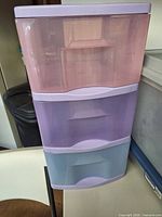 Three-drawer plastic storage tower showing colors and condition