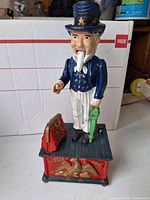 Front view of Uncle Sam cast-iron bank showing figure, suitcase, pedestal with eagle
