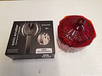 Ruby red candy jar with lid beside boxed BlackWolf Sonic Scrubber