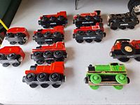 Underside view of multiple red, green, black Thomas & Friends magnetic trains