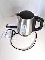 Kettle with base and manual displayed