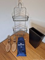 Group shot of shower caddy, Bombas slippers bag, Bally shoe trees, black metal vase