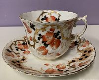 Teacup on saucer showing pattern, colors, and overall condition