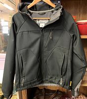 Front view of black Columbia Titanium hooded windbreaker on hanger