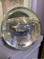 Clear art glass paperweight with purple core, bubbles, gold flecks