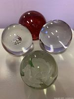 Four spherical glass paperweights arranged together