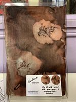 Front of packaged set showing scarf design, brand label and contents list