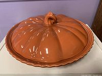 overview of pumpkin-shaped orange glazed ceramic covered pie plate