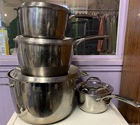 Stack of four stainless steel Lagostina pots with lids