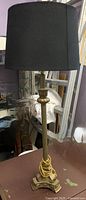 Full view of brass lamp with black shade