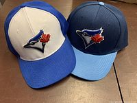 Two Toronto Blue Jays baseball caps showing colours and logo