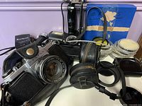 Overall view showing Pentax camera, leather case, pouches, flash, light meter, filters