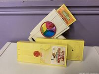 Movie viewer with three film cartridges showing labels Cookie Monster and Snoopy and unidentified cartridge