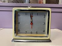 front view showing cream bezel, silver dial, numerals, hands, chrome base