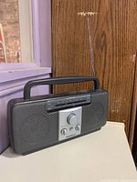 Front view showing speakers, control panel, handle and antenna