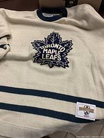 Full front view showing crest, stripes and hang tag