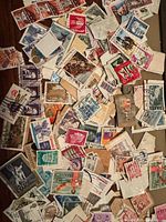 Top-down view of loose assorted stamps spread out showing variety of designs and countries